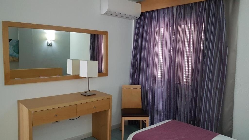 une chambre avec un lit violet et un miroir