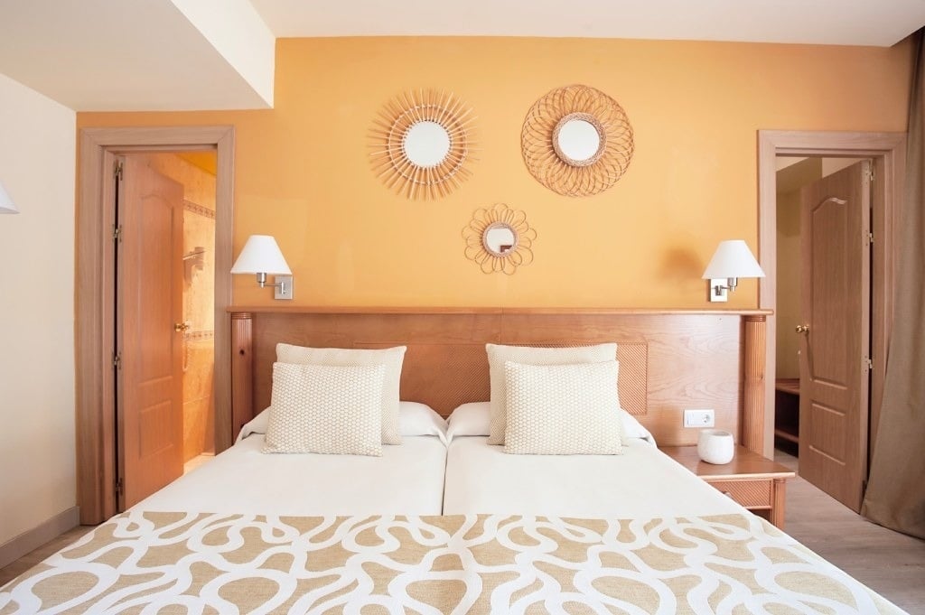 une chambre avec un lit et des miroirs sur les murs
