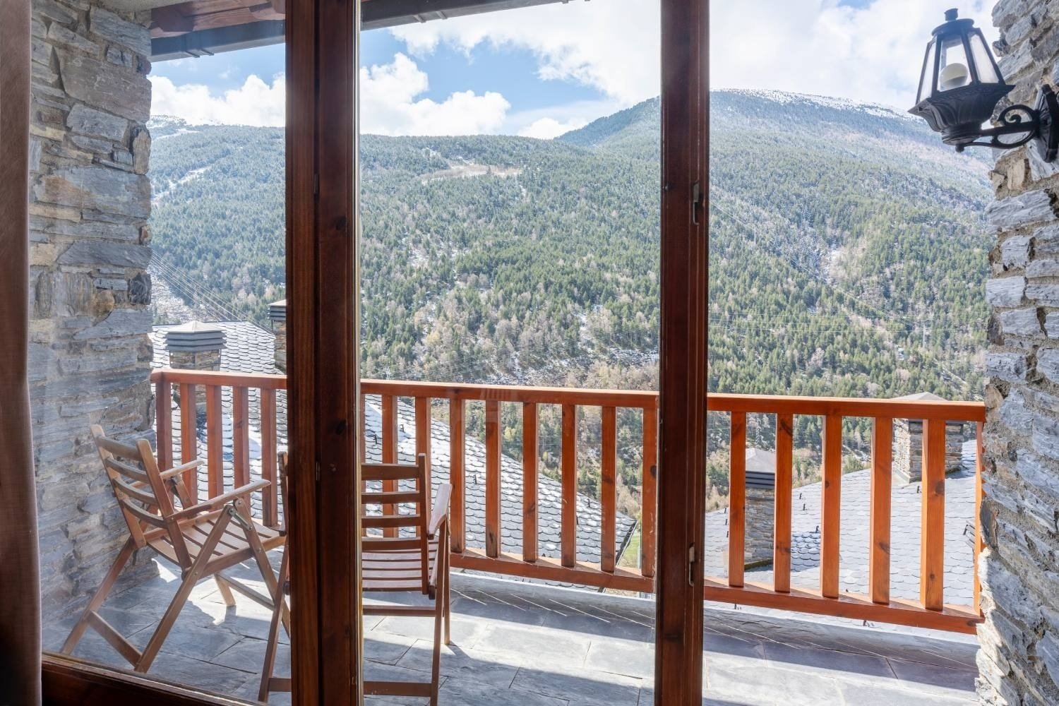 un balcon avec une chaise et une table avec vue sur les montagnes