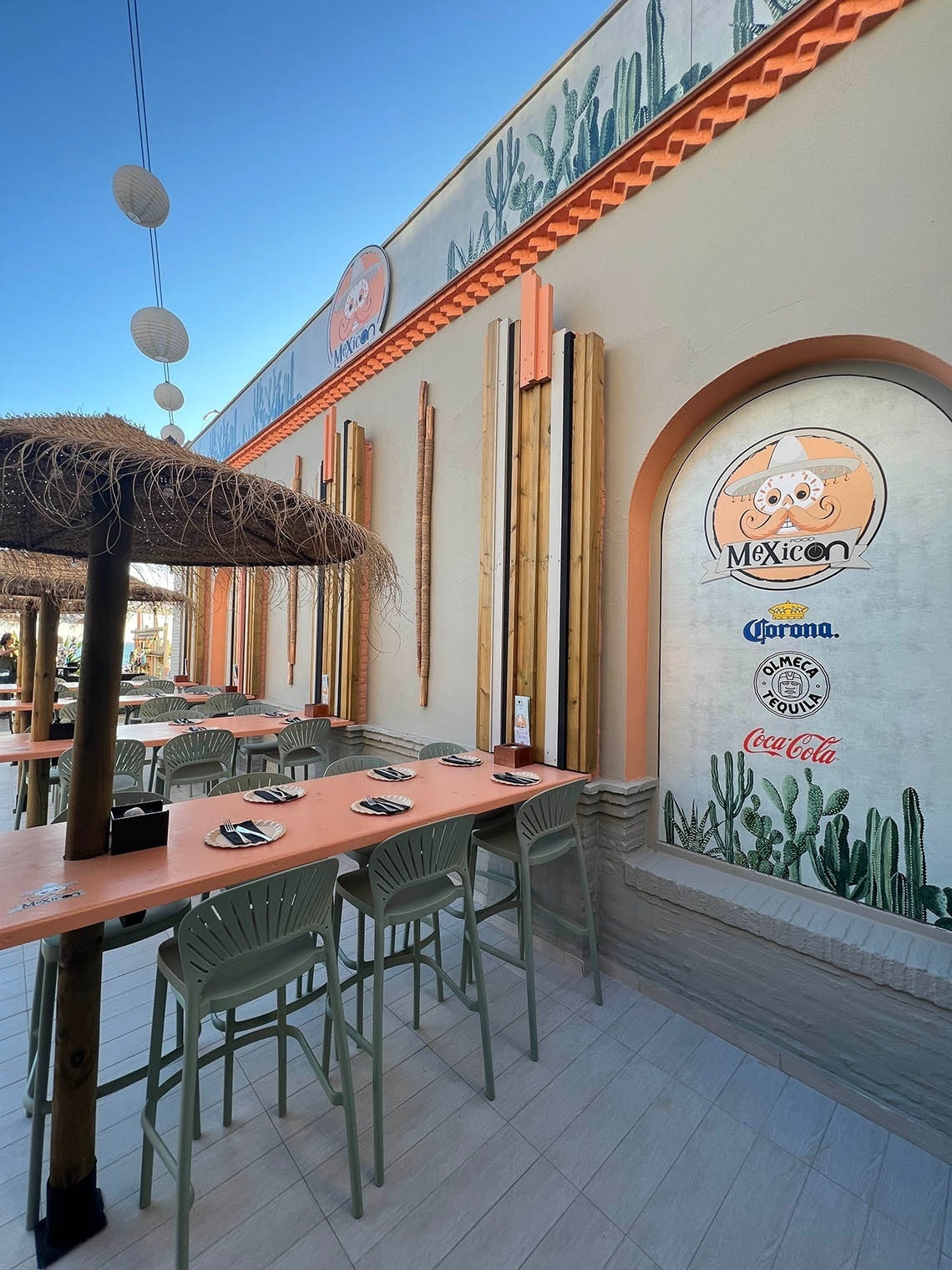 the outside of a mexican restaurant with tables and chairs