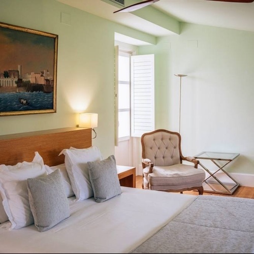 a bedroom with a large painting on the wall above the bed