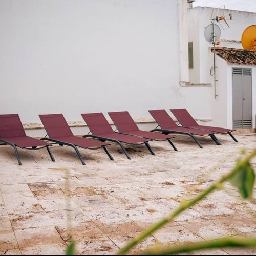 a row of red lounge chairs on a patio