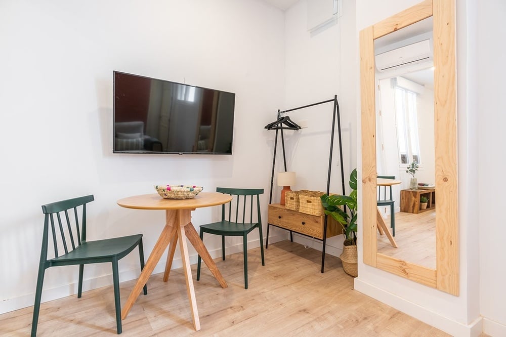 una mesa con dos sillas y un televisor en la pared