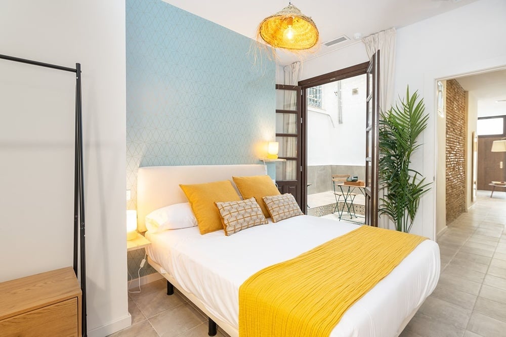a bedroom with a yellow blanket on the bed