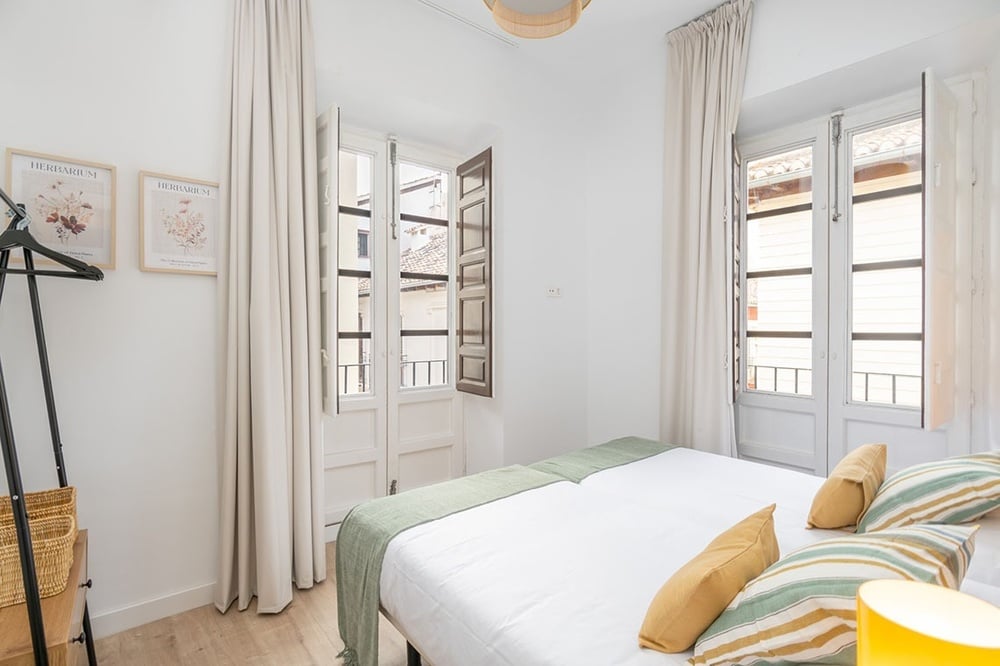 un dormitorio con una cama y dos carteles de hierbas en la pared