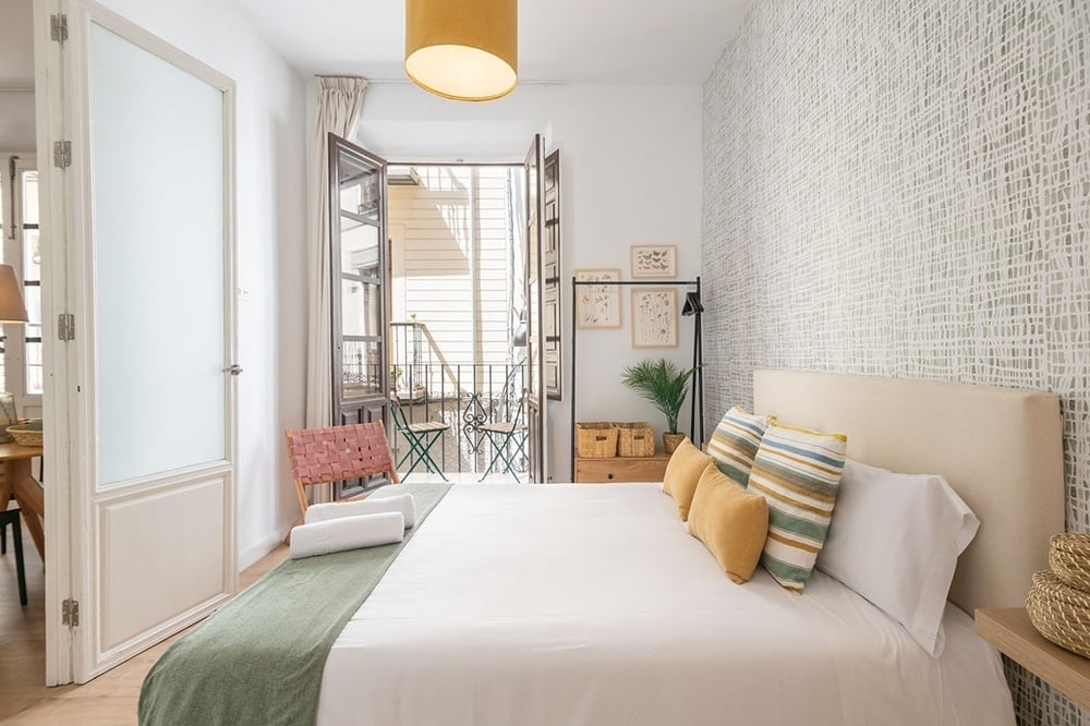 una habitación con una cama y una puerta que da a un balcón