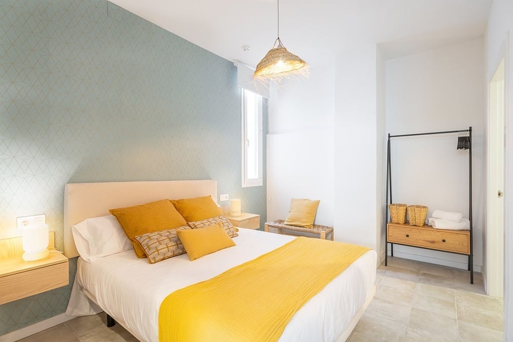 a bedroom with a white bed and yellow pillows