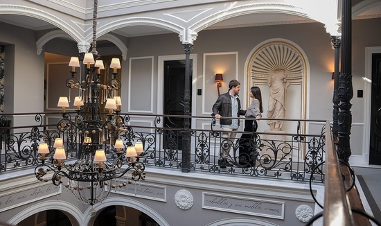 un hombre y una mujer se paran en un balcón de un edificio