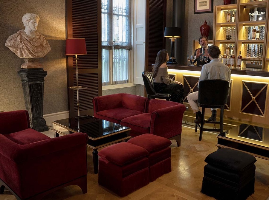 un hombre y una mujer están sentados en un bar en una habitación con muebles rojos