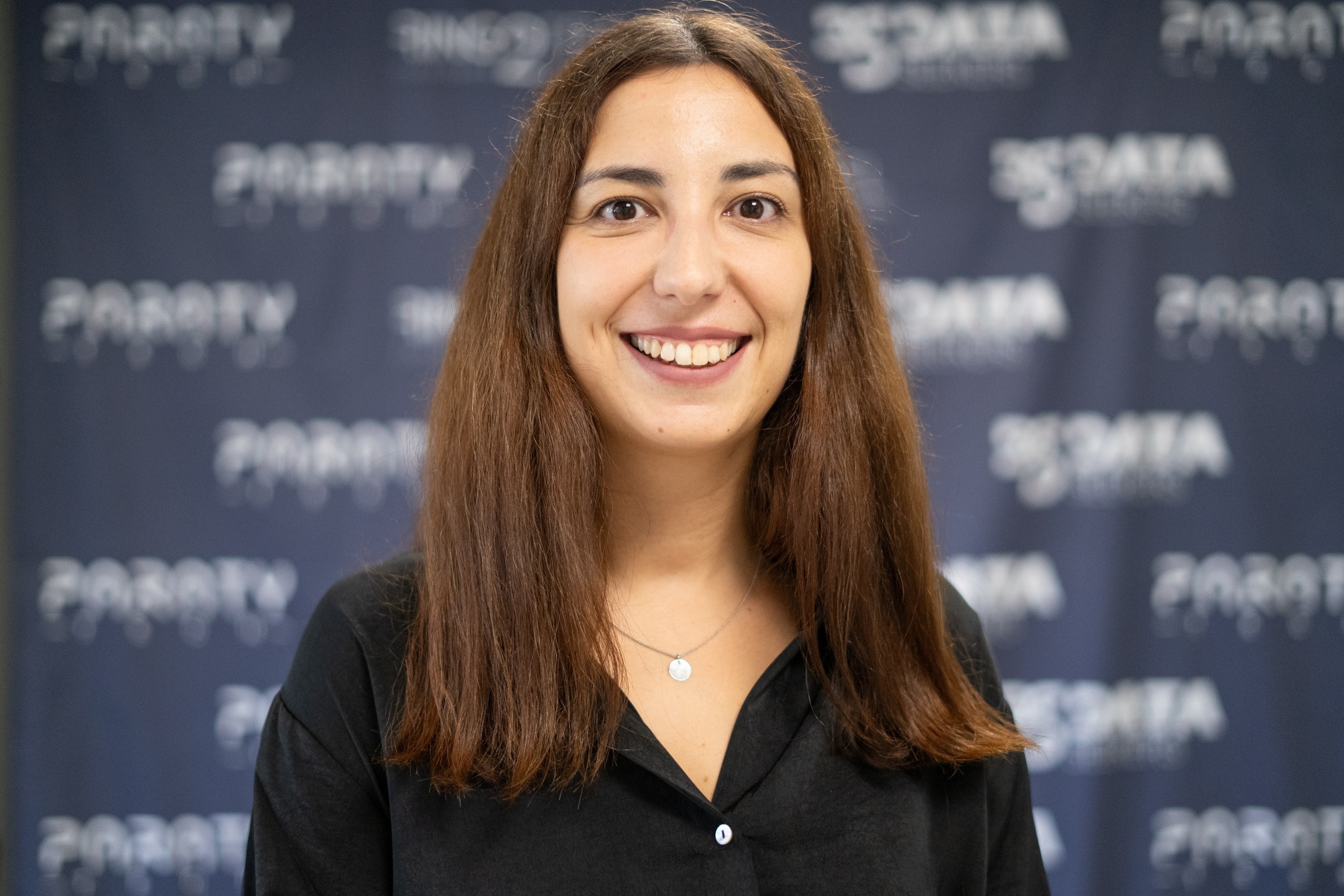 uma mulher está em frente a uma parede com o logotipo paraty