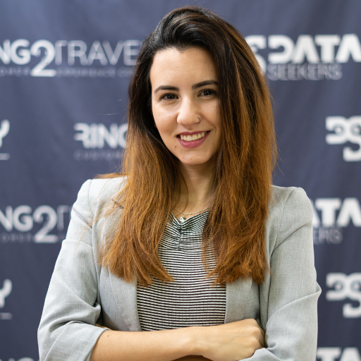 a woman wearing a black shirt and a necklace smiles in front of a sign that says data