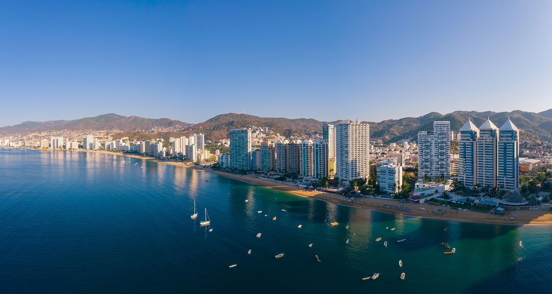 an aerial view of a city with mountains in the background