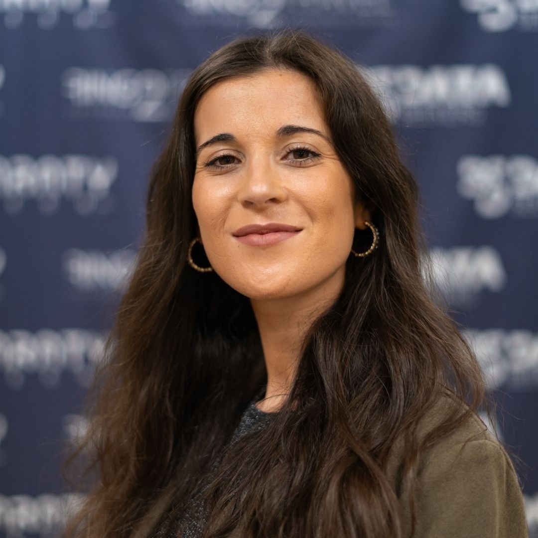 a woman wearing hoop earrings stands in front of a blue background that says ' angry birds ' on it