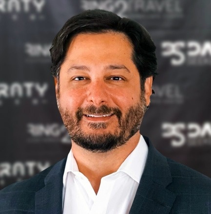 un hombre con traje y camisa blanca sonríe para la cámara