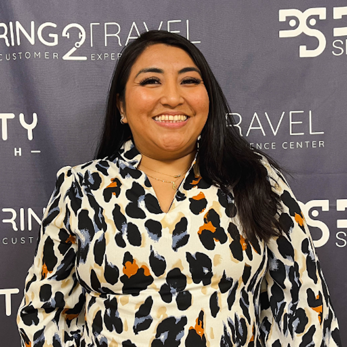 a woman wearing a white shirt and a gold necklace smiles for the camera