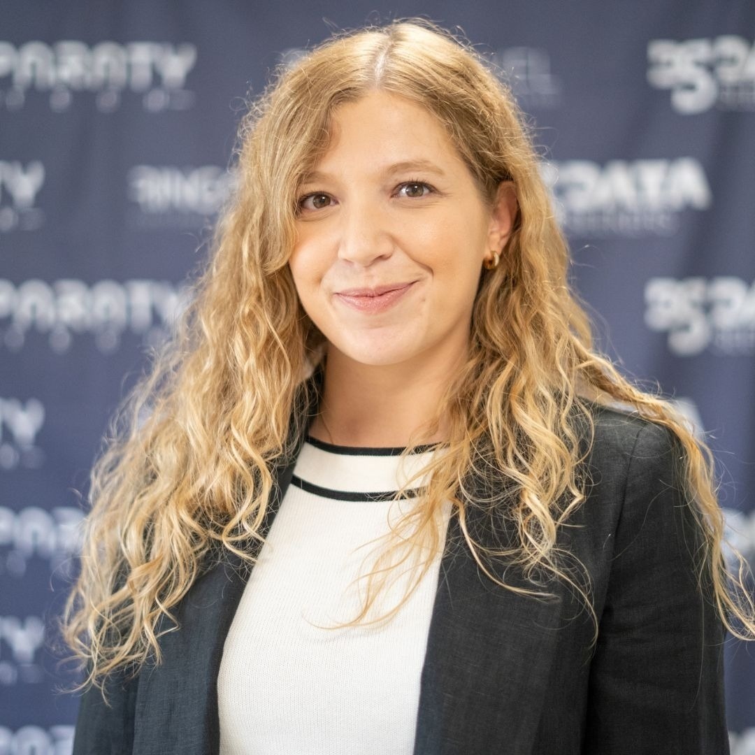 a woman stands in front of a blue background that says data