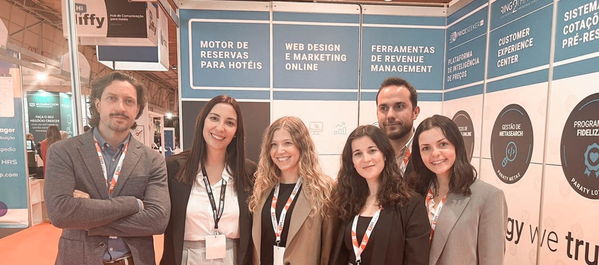 um grupo de pessoas está posando para uma foto em frente a uma parede com as palavras " motor de reservas para hotéis "