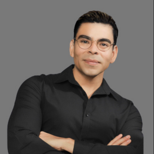 a woman wearing a white shirt and a gold necklace smiles for the camera