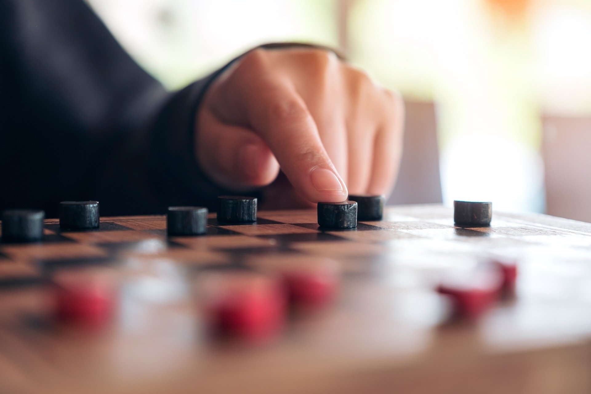 a person is playing a game of checkers with their finger