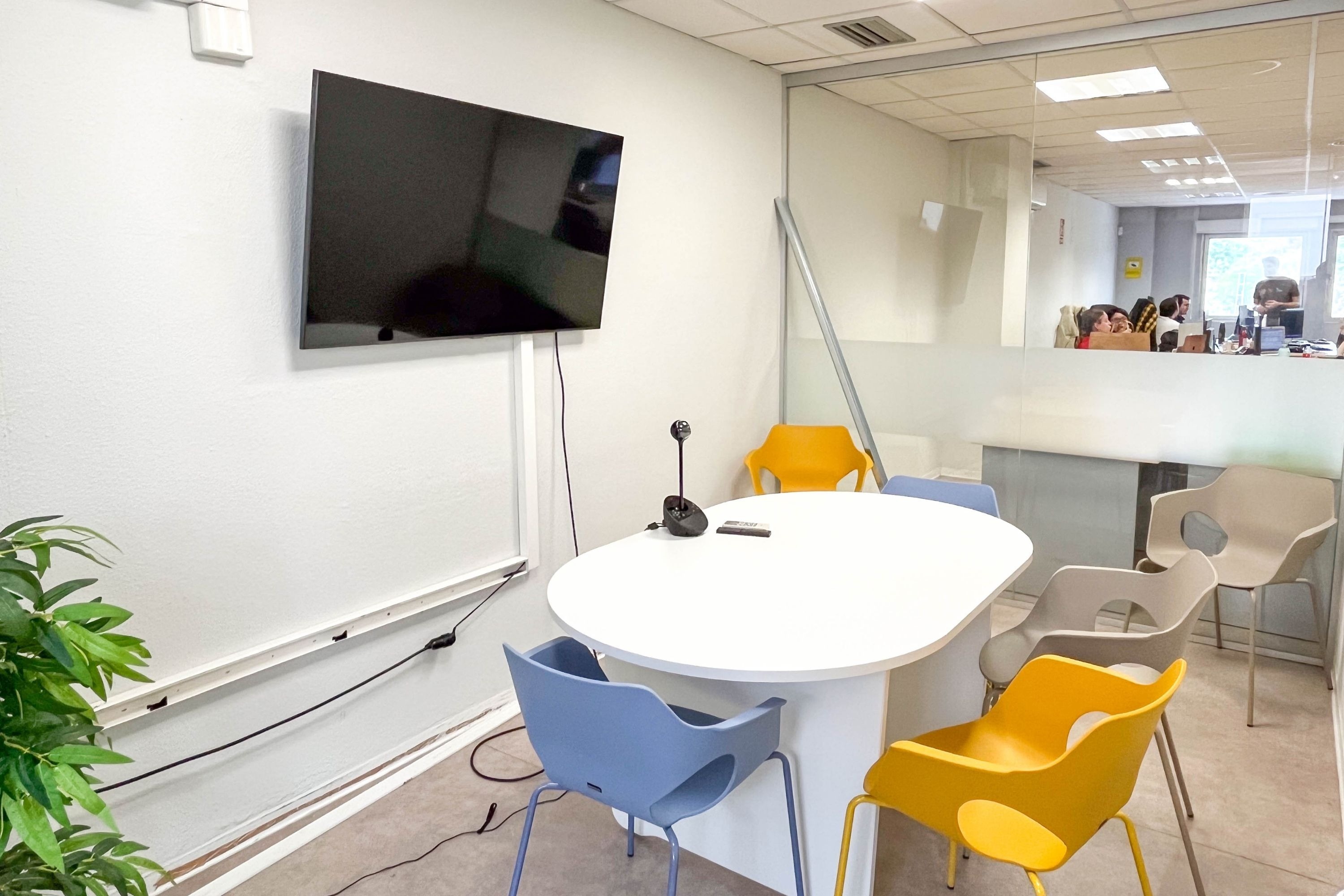 a conference room with a table and chairs and a flat screen tv