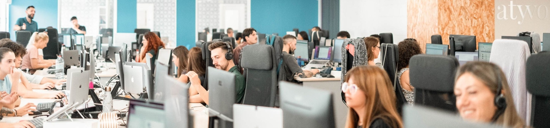 um grupo de pessoas está trabalhando em computadores em um escritório