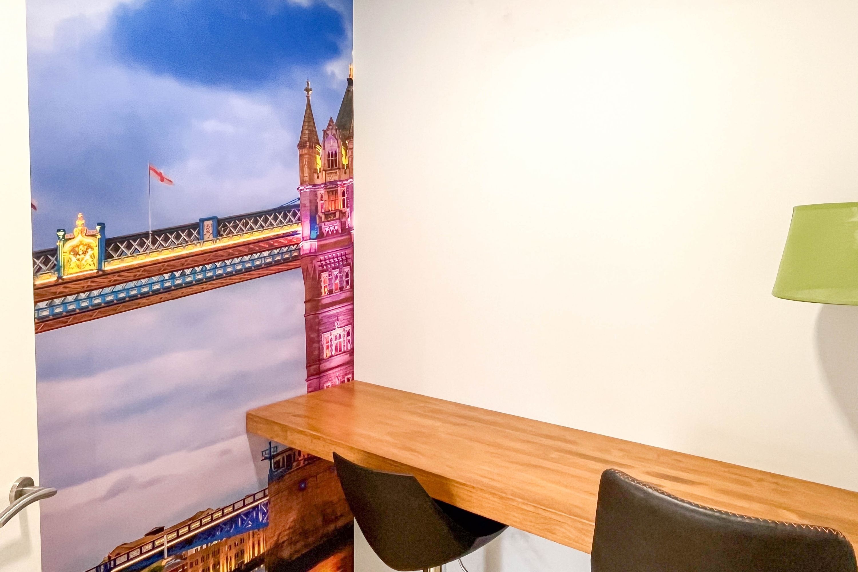 uma mesa de madeira com uma pintura de uma ponte na parede