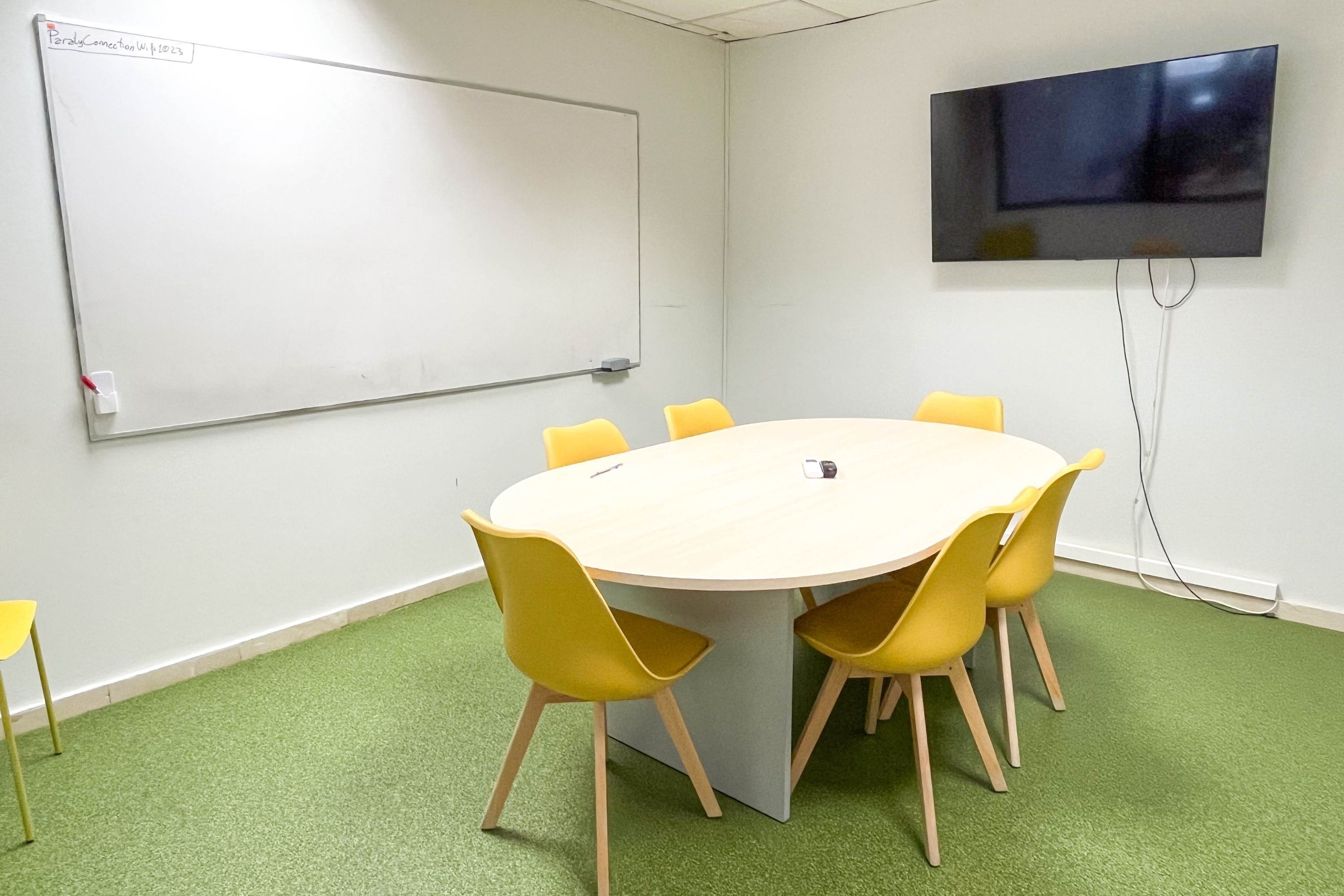 a conference room with a round table and yellow chairs