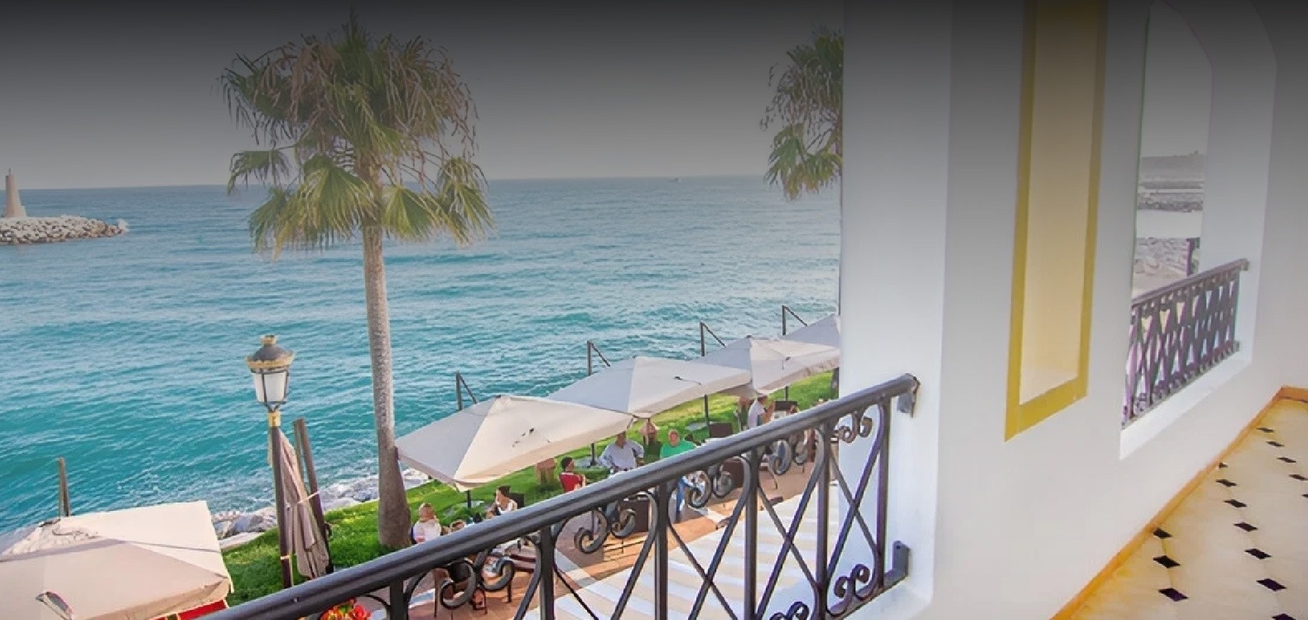 dos tumbonas blancas en un balcón con vistas al océano