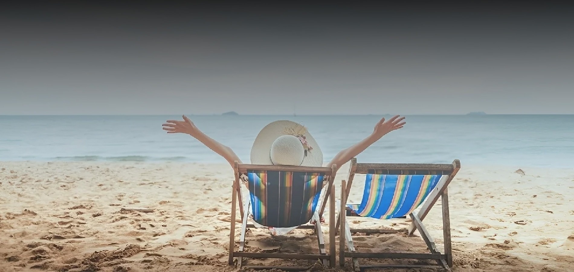 a woman sits in a beach chair with her arms outstretched