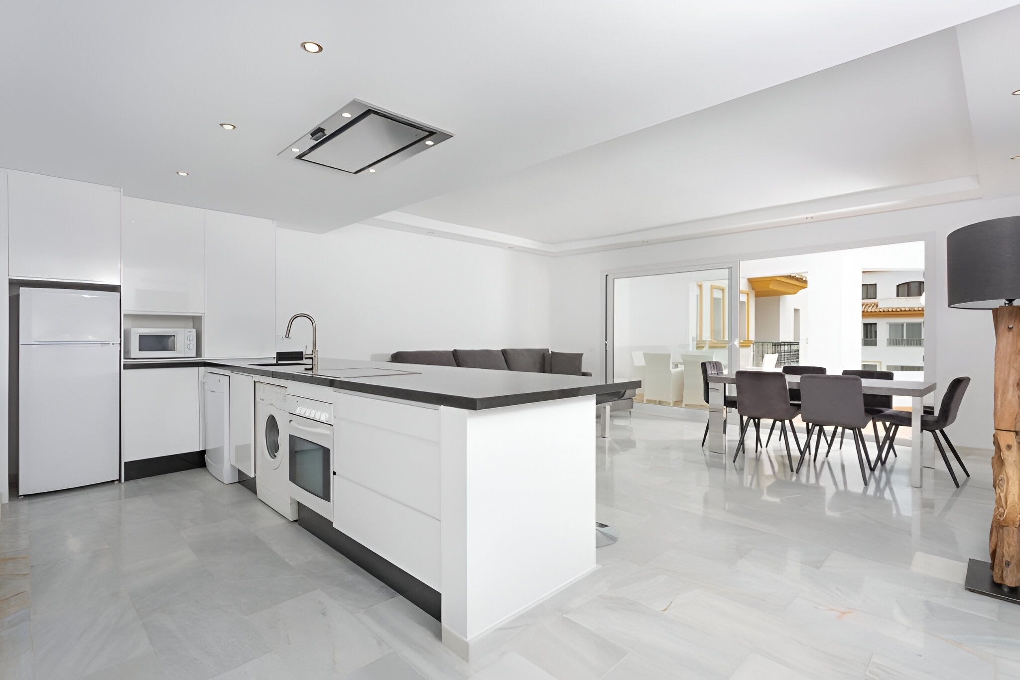 una cocina con electrodomésticos blancos y una mesa de comedor