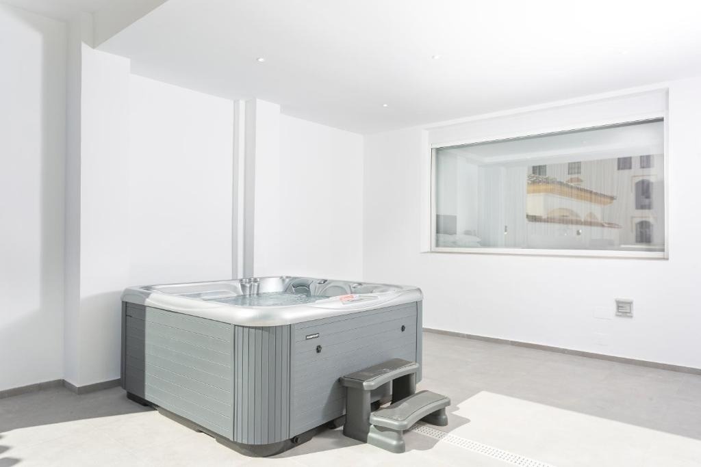 un jacuzzi en una habitación blanca con una ventana