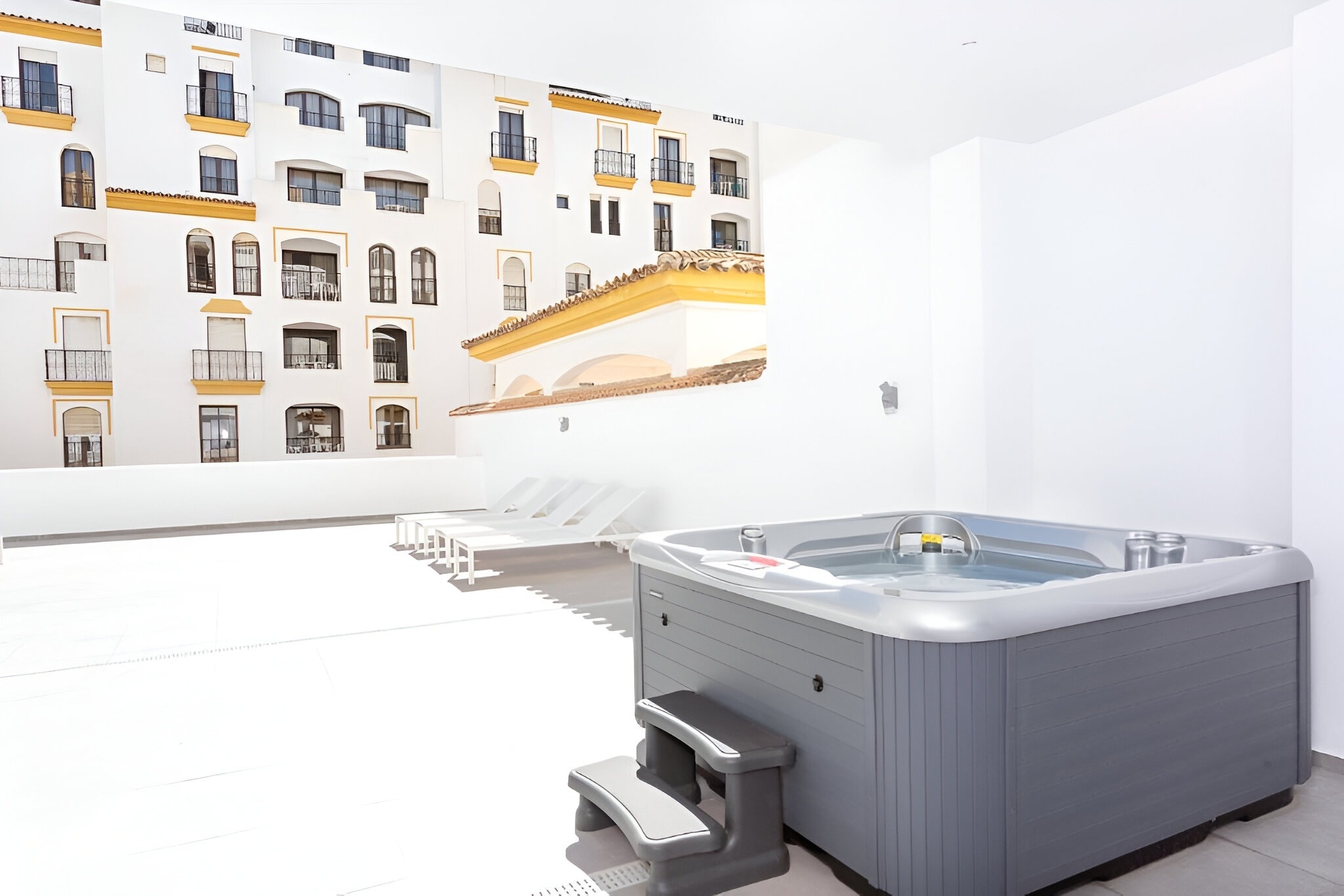 un jacuzzi en una habitación con un edificio blanco en el fondo