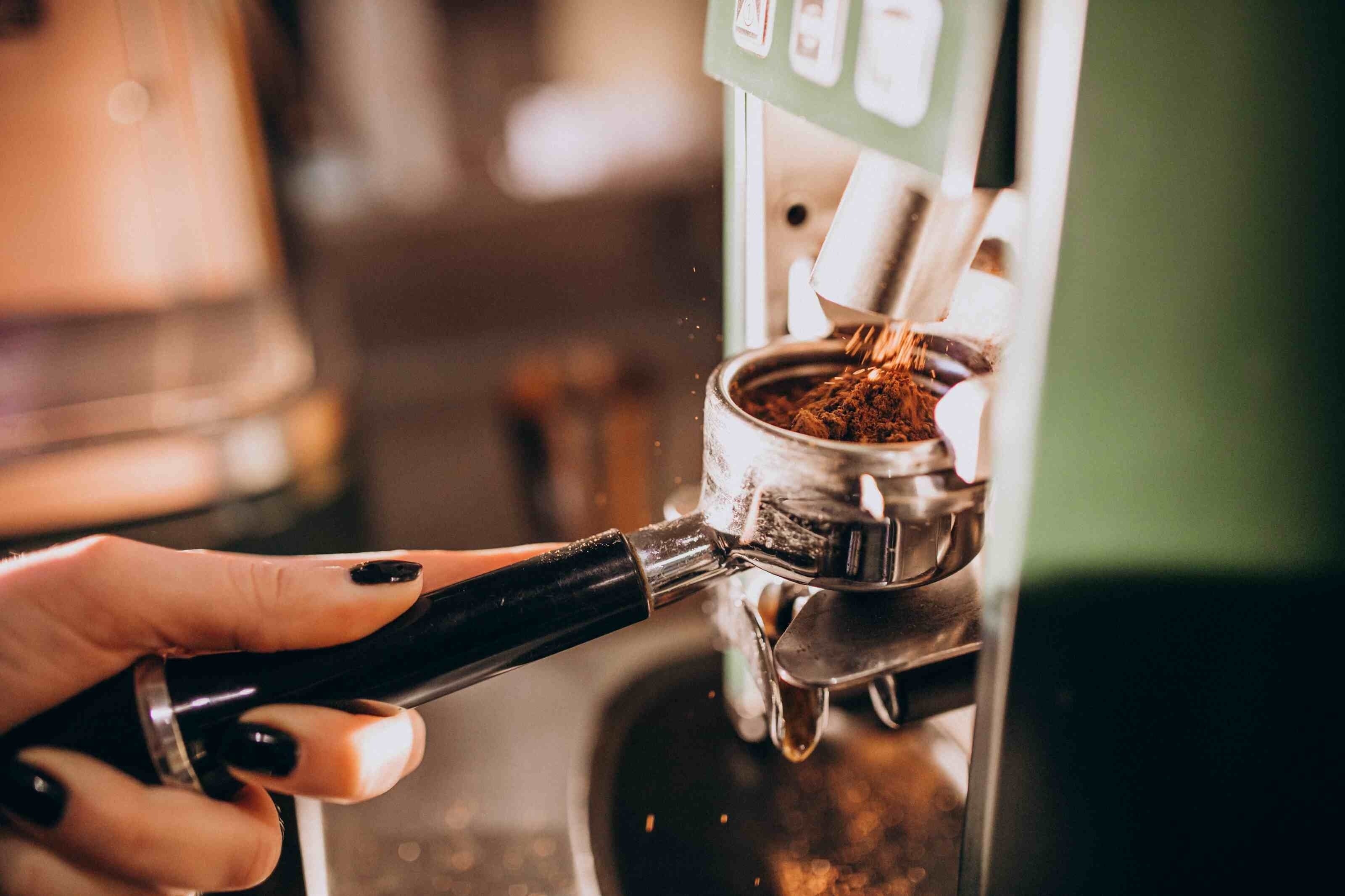 uma mulher está preparando café em uma máquina de café