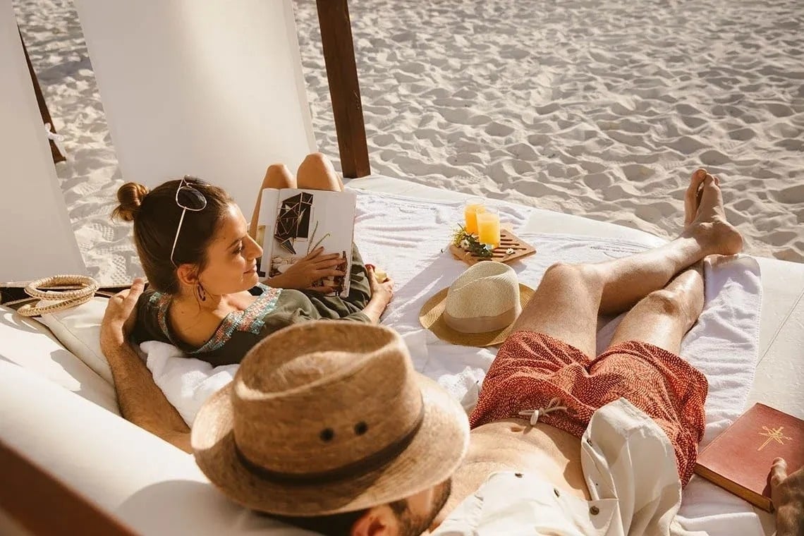 um grupo de pessoas sentadas em posição de lótus na praia