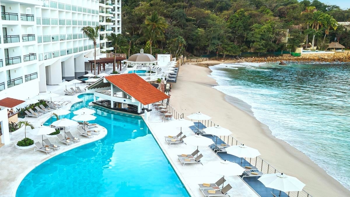 a large swimming pool surrounded by white chairs and umbrellas