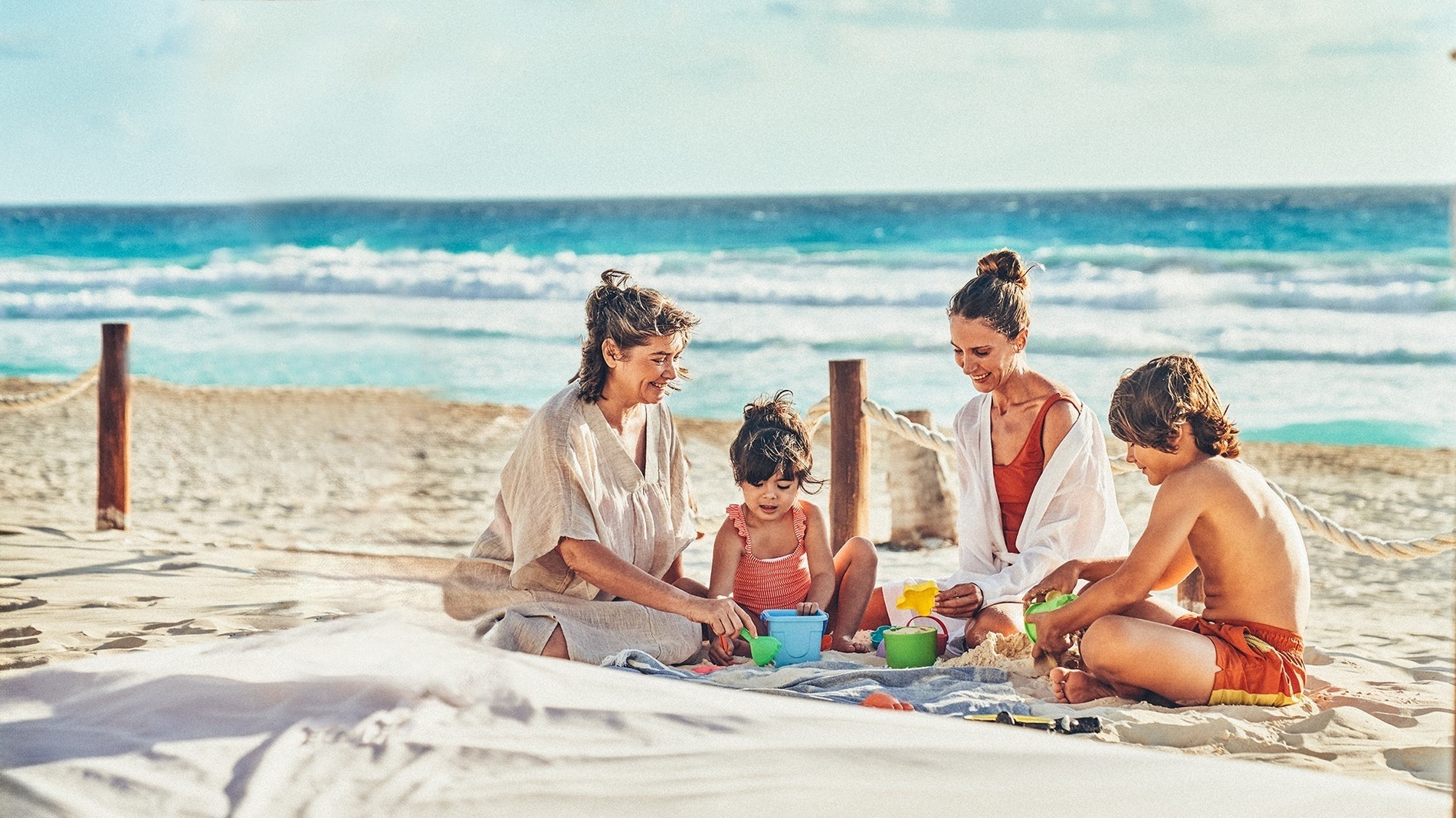 una familia juega en la arena en la playa