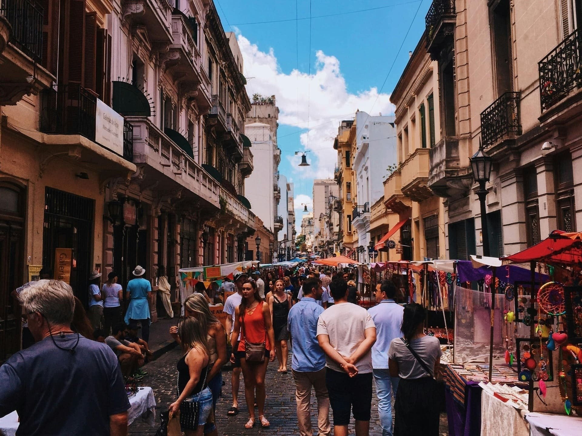 a crowd of people are walking down a busy street