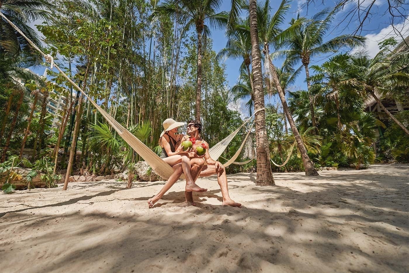 Pareja en hamaca con cocos en Park Royal: Corpo, Tulum. Disfruta la playa.