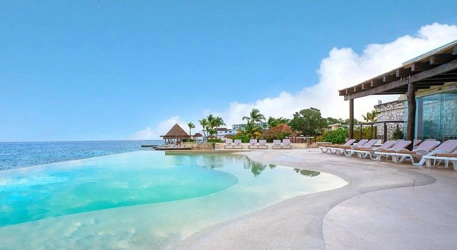 a large swimming pool with a view of the ocean
