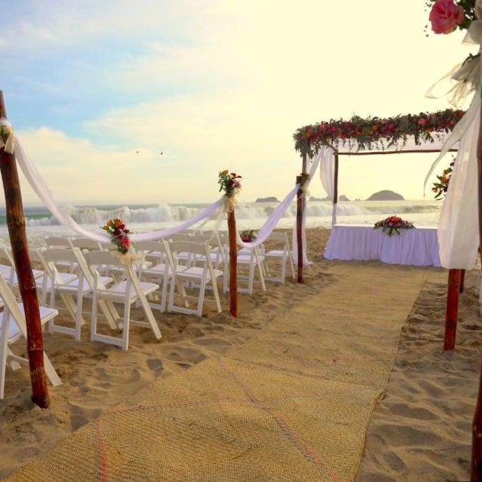 Camino al altar decorado con flores en la playa del Hotel Park Royal Beach Ixtapa