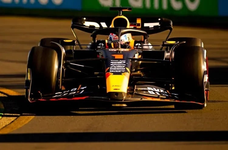 un coche de carreras conduce por una pista de carreras por la noche