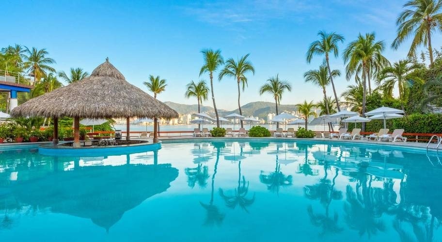 Bar, piscina exterior, hamacas y palmeras del Hotel Park Royal Beach Acapulco