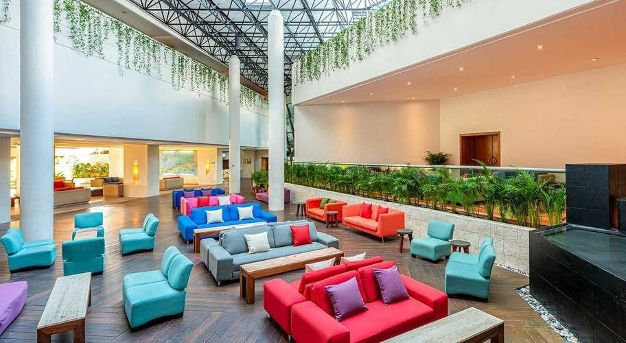 Large reception area with armchairs, tables and a fountain at Park Royal Beach Ixtapa