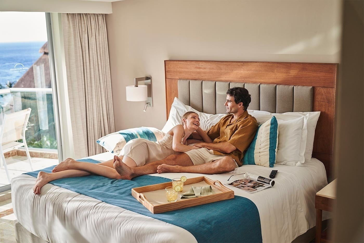 Pareja relajada en una suite de Park Royal: Corpo, disfrutando de vistas al mar.