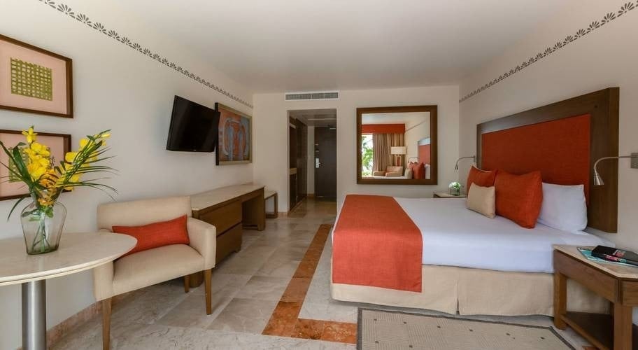 Quarto com cama e sofás no Grand Park Royal Cancun Hotel