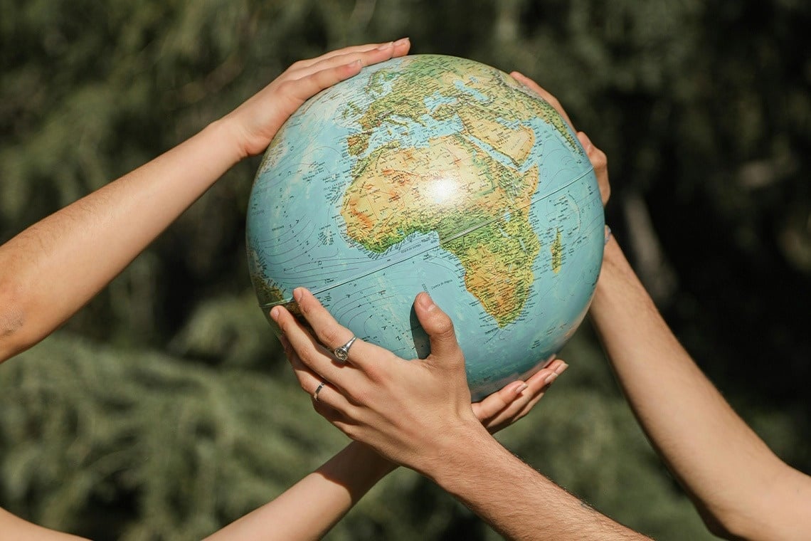 a group of people are holding a globe in their hands