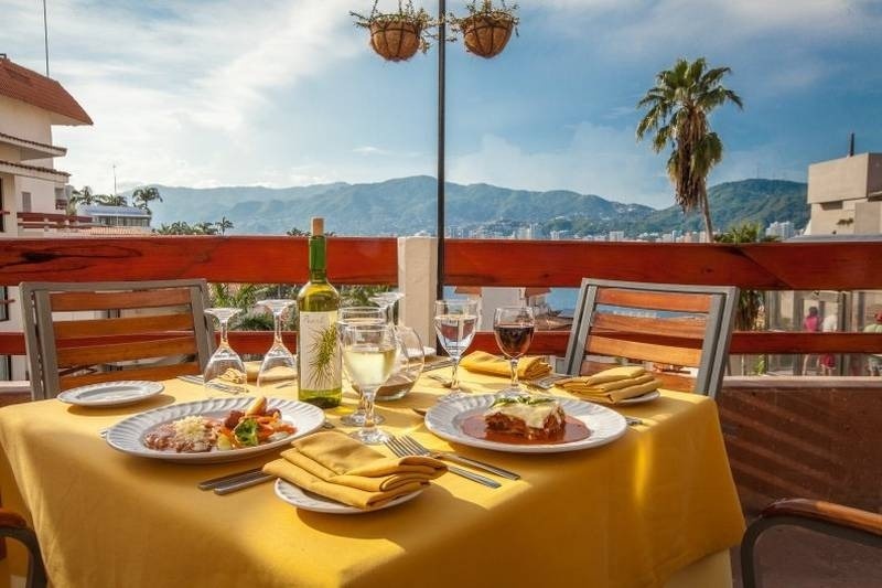 Terrace with a table set with dishes and drinks at the Park Royal Beach Acapulco Hotel