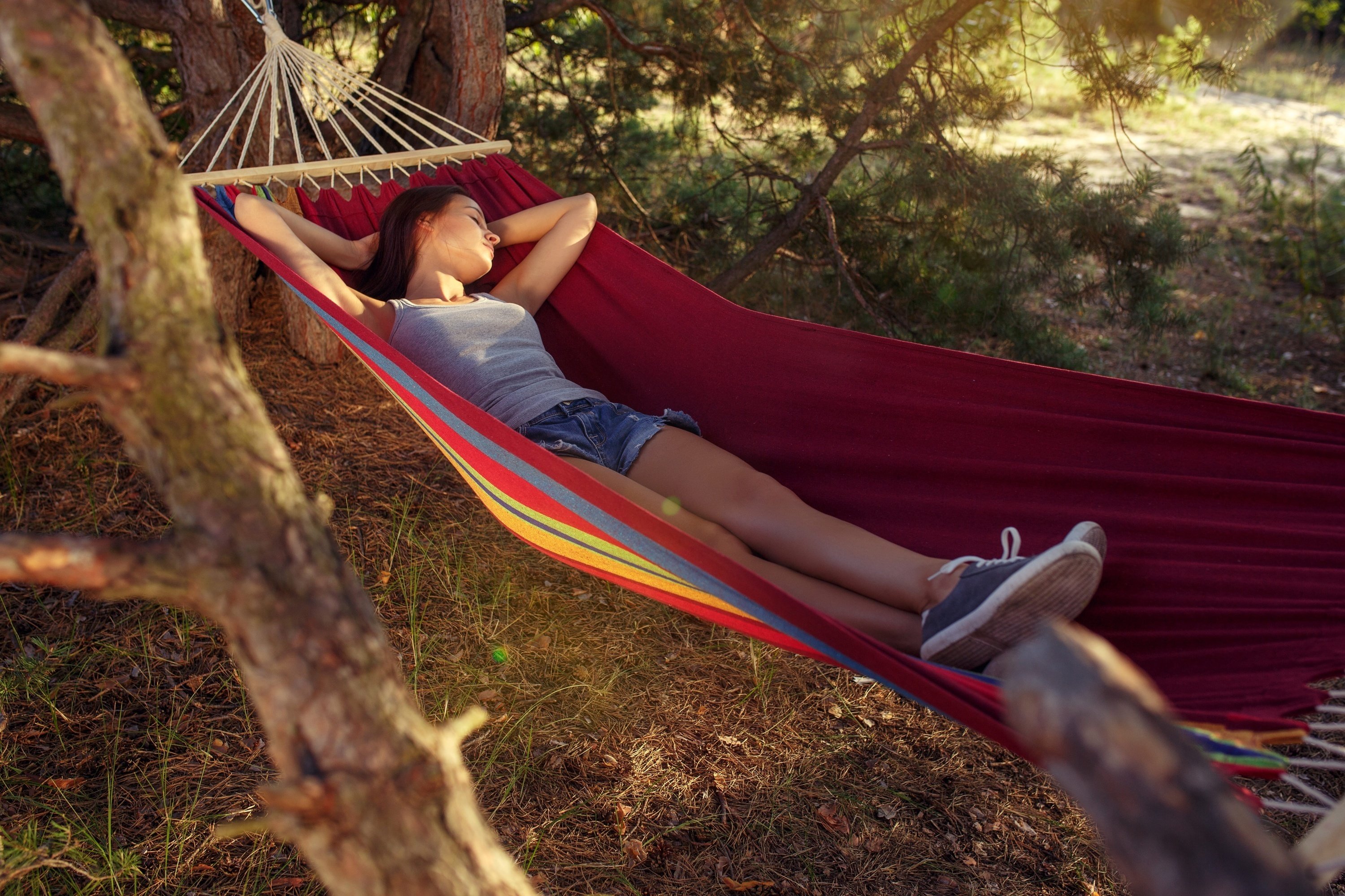 Imagem de uma pessoa descansando em uma rede estilo mexicano