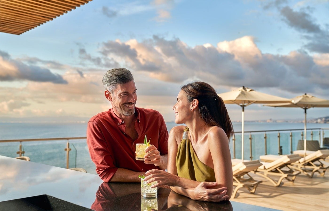 Pareja brindando en bar con vistas al mar, Hotel Grand Park Royal Puerto Vallarta | Pacífico Mexicano.