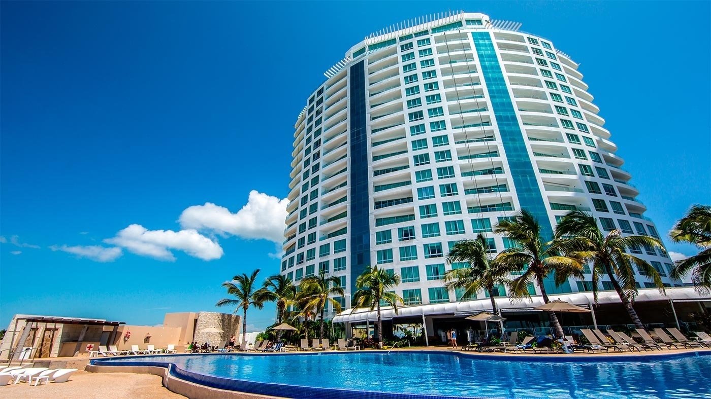 un gran edificio blanco y azul con una piscina al frente